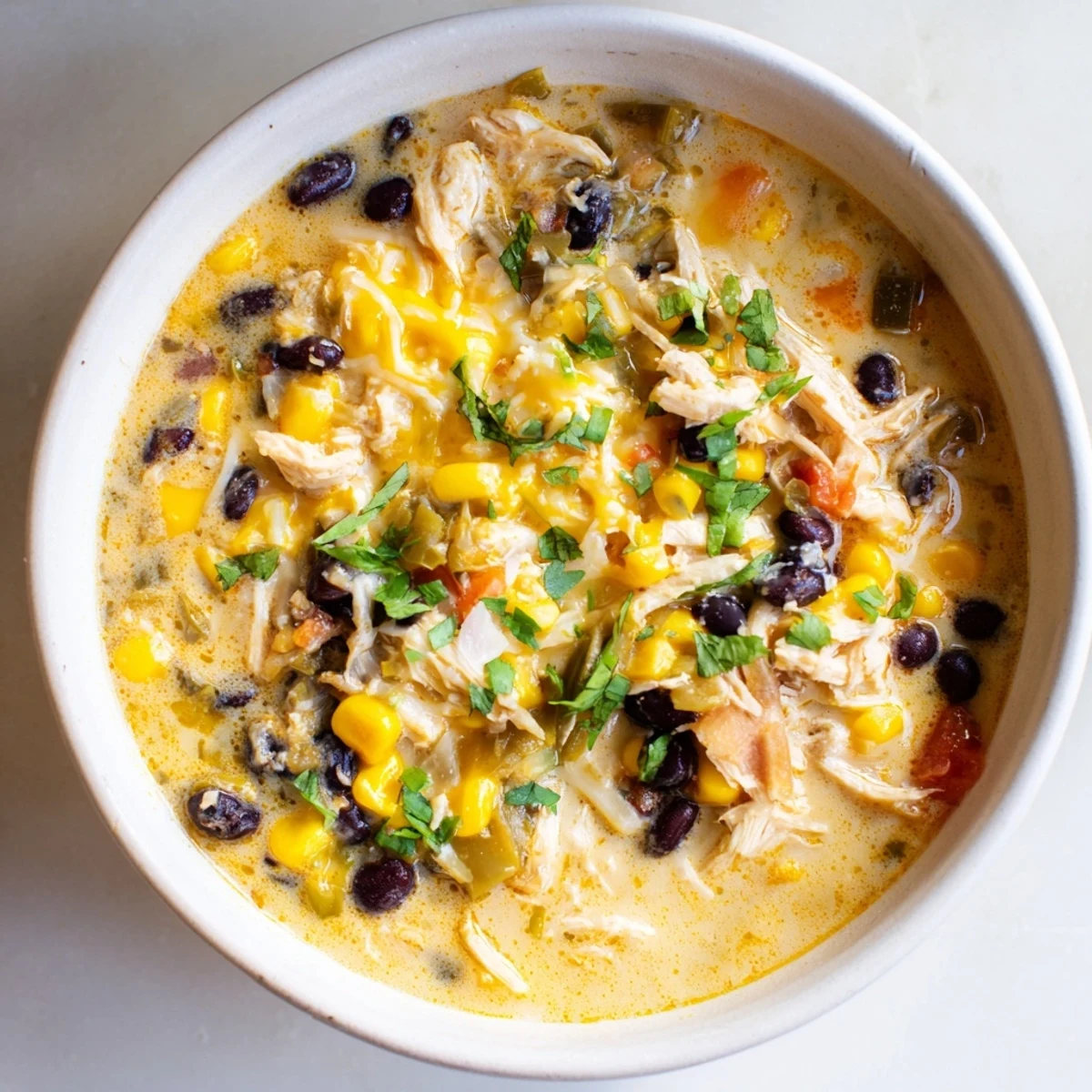 Chicken Poblano Soup, a creamy bowl of comfort, showcasing shredded chicken and smoky poblano peppers.