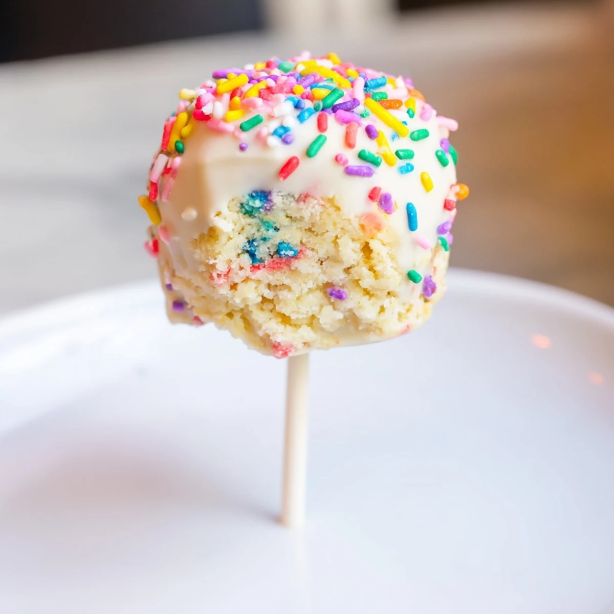 Soft, white chocolate-dipped Lightened-Up Sugar Cookie Cake Pops with colorful sprinkles ready to enjoy.