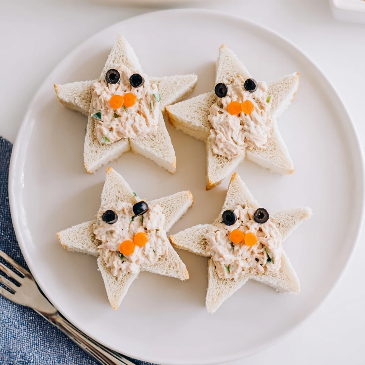 Mini Starfish Sandwiches: golden bread stars filled with tuna, olive eyes, perfect for a fun appetizer.