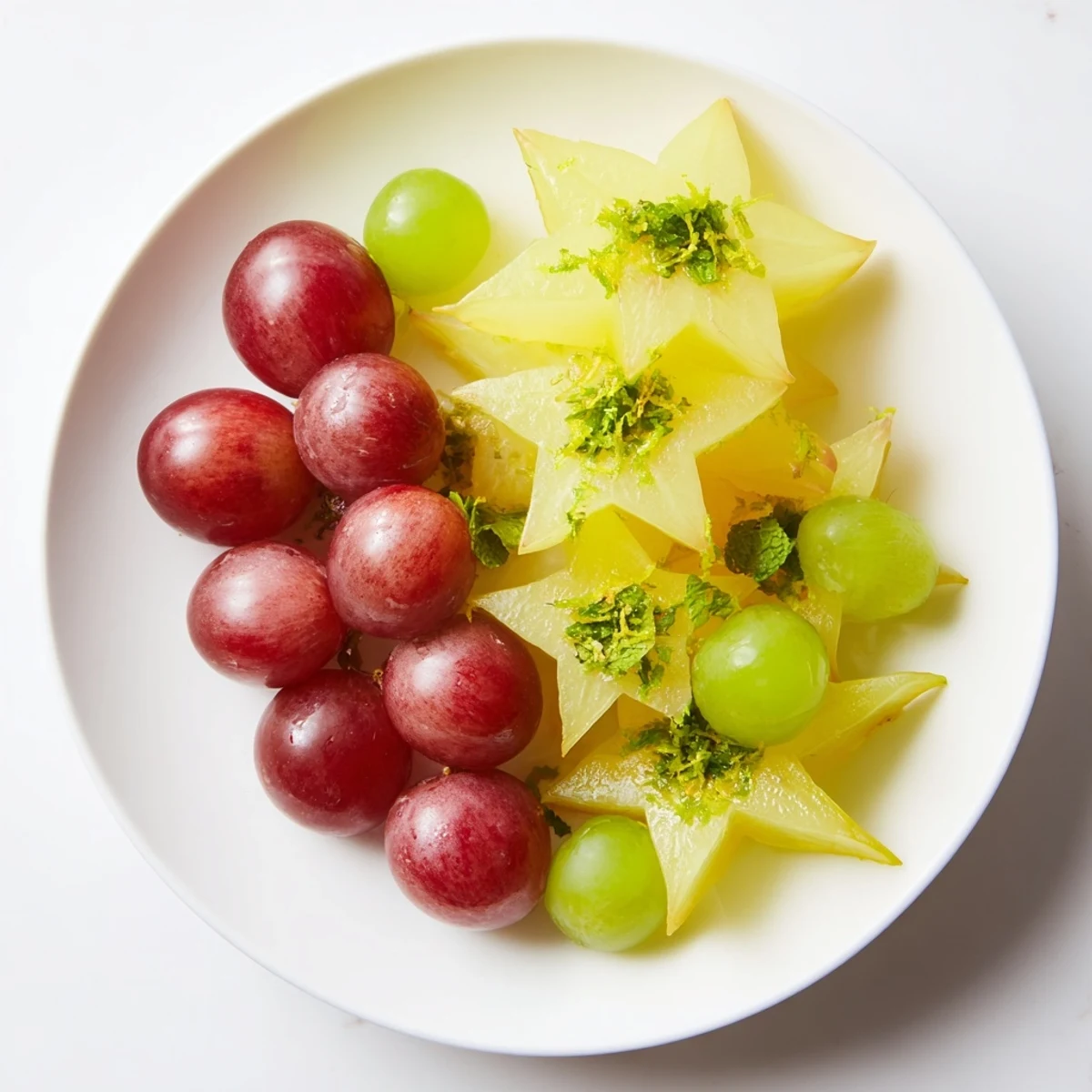 Fresh brunch fruit featuring sliced starfruit and halved grapes, a vibrant, refreshing dish to serve.