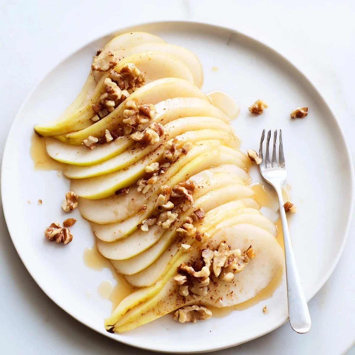 Fresh pear slices with golden honey drizzle, a simple yet elegant dessert for two.