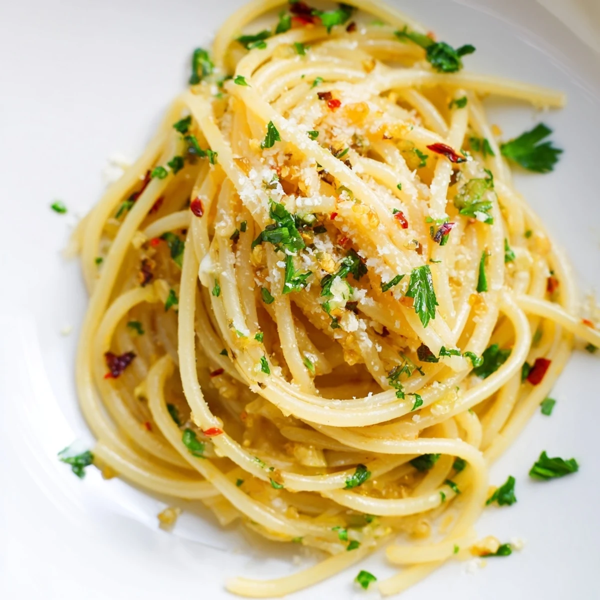 Steaming Aglio e Olio Express Pasta, glistening with olive oil and speckled with parsley, ready to eat.