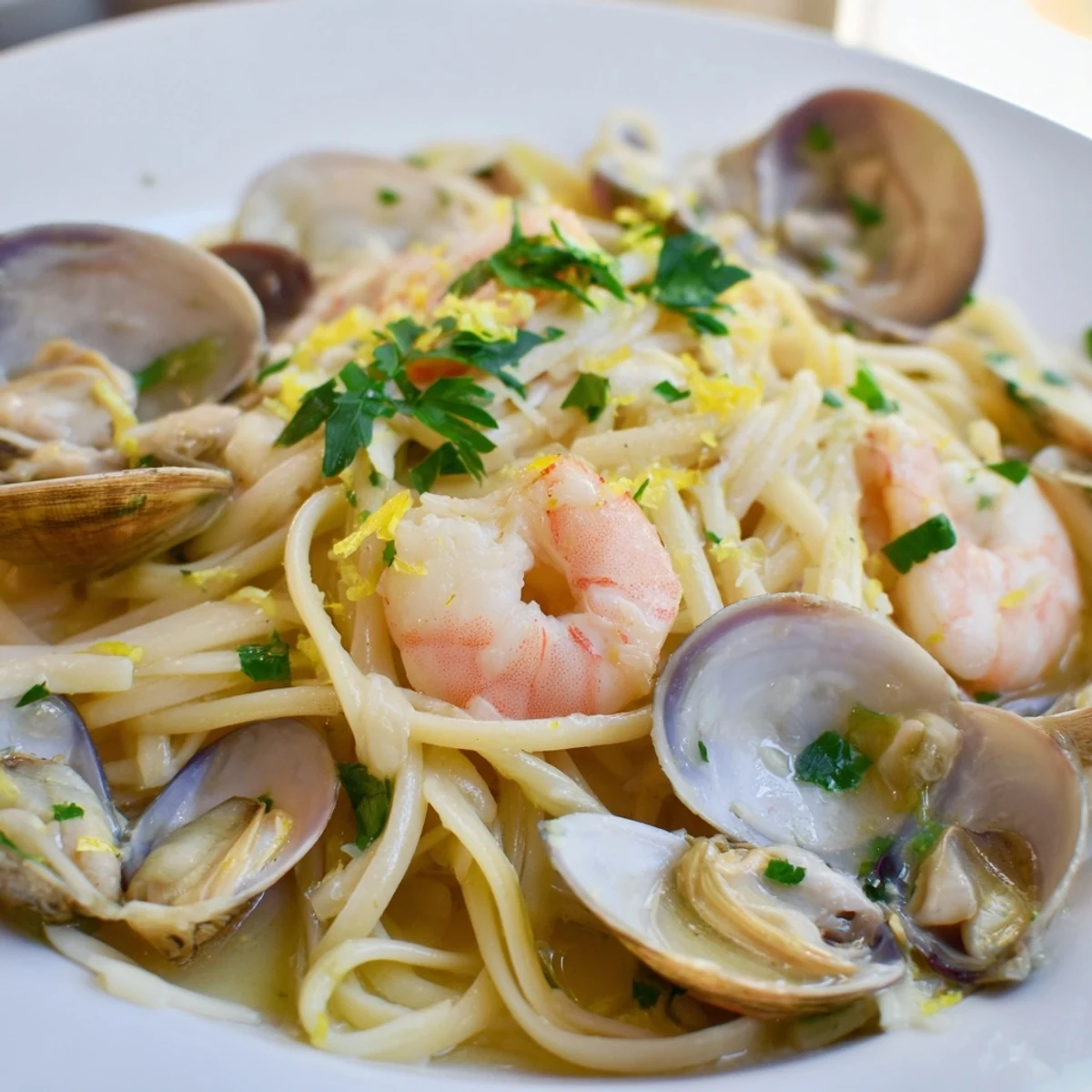 Plated Seafood Linguine with bright parsley, lemon wedges, and buttery white wine sauce, ready for a cozy Italian-inspired dinner.