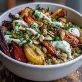 A close-up of the Roasted Root Vegetable Bowl with caramelized parsnips and turnips, a tahini drizzle, and fresh parsley on quinoa.