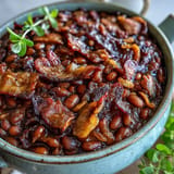Hearty Juneteenth BBQ Baked Beans with crispy bacon topping ready for your picnic spread.