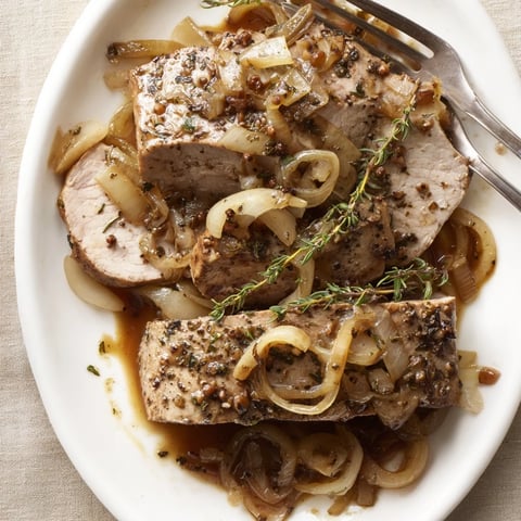 Succulent Savory Apple Cider Pork Roast surrounded by caramelized onions and apples.  