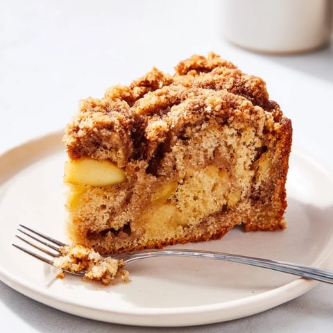 Delicious Cinnamon Swirl Apple Crumble Cake topped with crunchy crumble, ideal for dessert.  