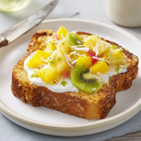 Creamy yogurt-custard toast topped with tropical fruits for a refreshing breakfast.  