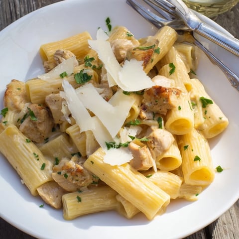 Creamy Garlic Parmesan Chicken Rigatoni topped with fresh herbs and grated cheese.  