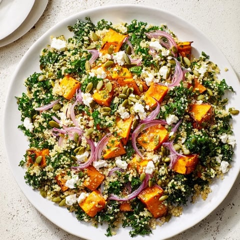 Kale & Quinoa Salad features roasted sweet potatoes, a lemon dressing, and vibrant colors in a bowl.