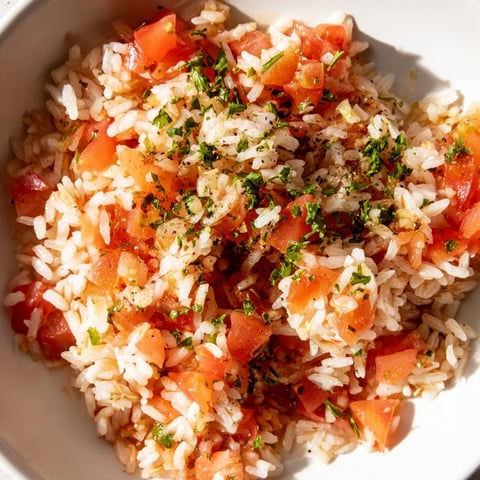 Steaming Tomato-Rice Skillet Dinner, a colorful one-pan meal with fresh parsley garnish.