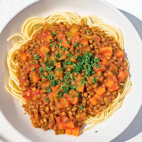Steaming bowl of Hearty Lentil Bolognese, a hearty vegan meal served over pasta.
