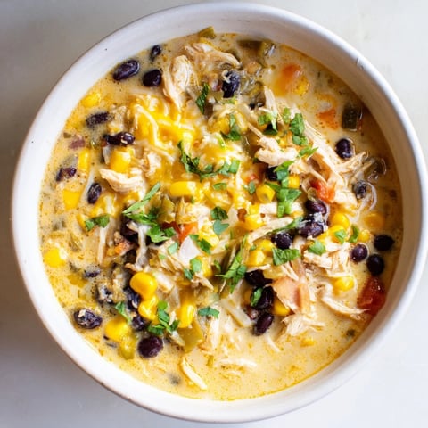 Chicken Poblano Soup, a creamy bowl of comfort, showcasing shredded chicken and smoky poblano peppers.