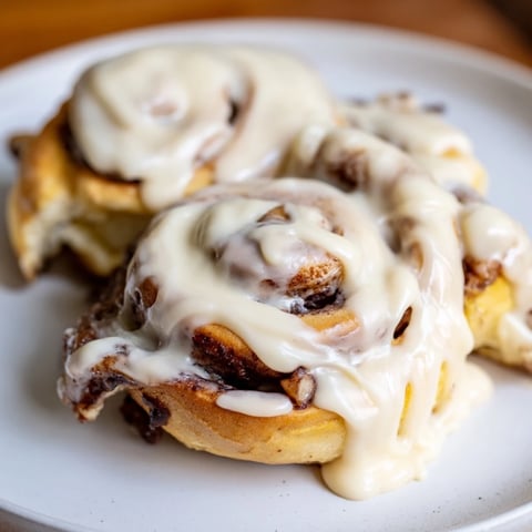 Warm, glazed TikTok Heavy Cream Cinnamon Rolls on a plate, smelling of fresh cinnamon and vanilla.