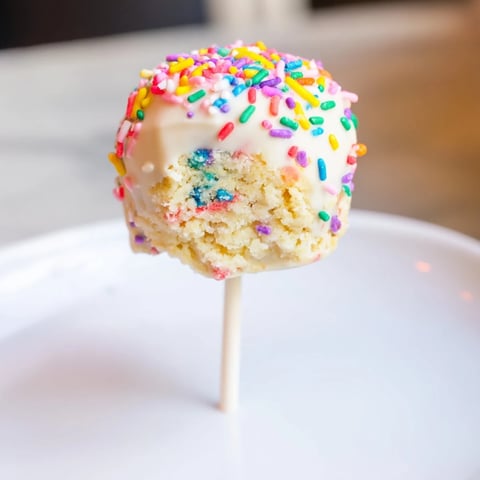 Soft, white chocolate-dipped Lightened-Up Sugar Cookie Cake Pops with colorful sprinkles ready to enjoy.