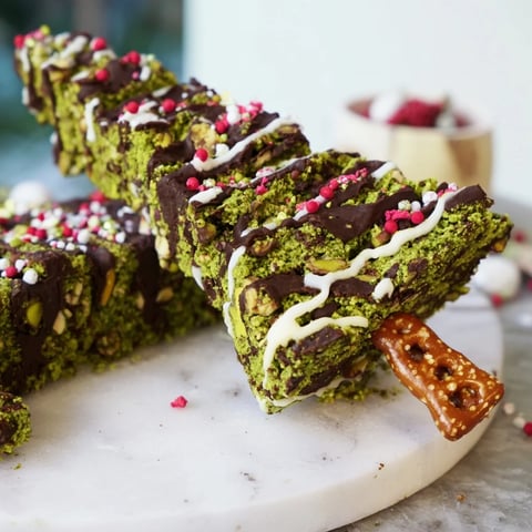 Matcha Pistachio Christmas Tree Blondie Bars, cut into festive tree shapes, drizzled with white chocolate and sprinkles.