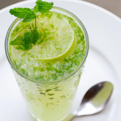 Refreshing pitcher of Mint Lime Agua Fresca, showcasing vibrant mint leaves and lime slices in summer.