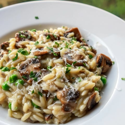 Creamy Orzo Mushroom Risotto-Style in a skillet, garnished with fresh parsley and shaved Parmesan.
