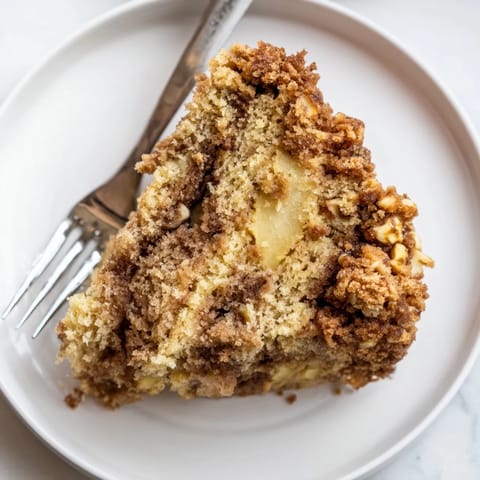 Moist, spiced Cinnamon Swirl Apple Crumble Cake with warm apple layers and buttery crumble.  