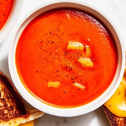 Warm, flavorful 5-Ingredient Tomato Soup served with bubbly, cheesy grilled cheese sandwiches for comfort.