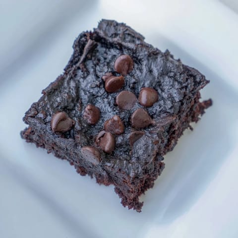These homemade Black Bean Brownies show a rich, moist texture with visible, dark chocolate flecks throughout the brownie.