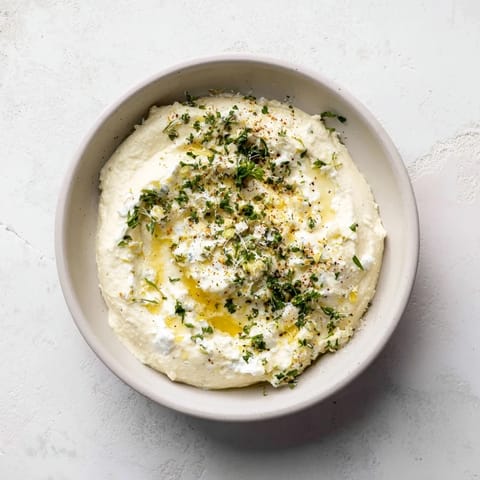 This vibrant dish of Angel Wings whipped feta, with a sprinkle of herbs, served with pita chips.