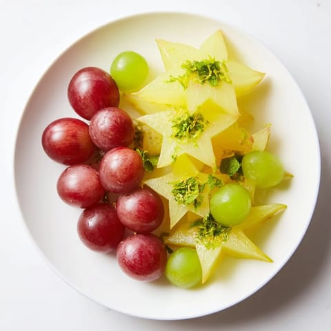 Fresh brunch fruit featuring sliced starfruit and halved grapes, a vibrant, refreshing dish to serve.