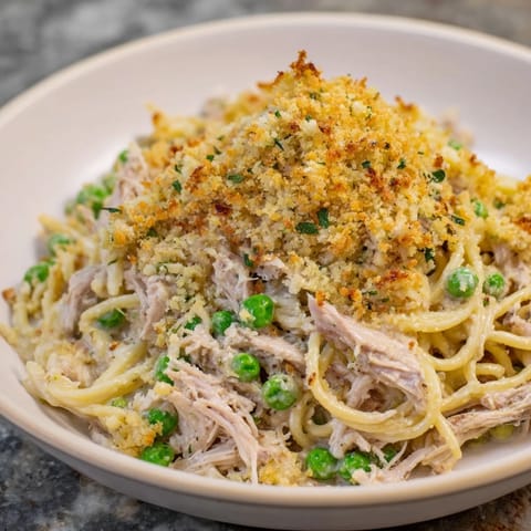 Creamy Turkey Tetrazzini bake: tender shredded turkey, pasta, and peas baked together beautifully.