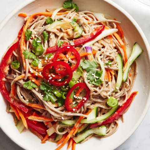 A vibrant bowl of soba noodle salad, showcasing tender noodles and fresh, crunchy veggies ready to enjoy.