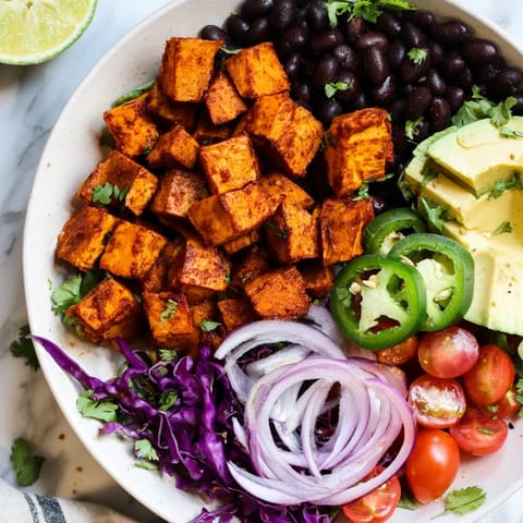 A close-up of a vibrant sweet potato taco bowl, showcasing tender sweet potatoes and fresh toppings, ready to eat.