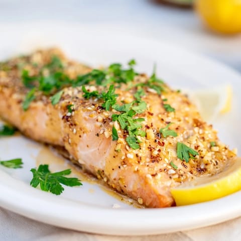 Oven-baked Honey Mustard Salmon with parsley garnish, promising a sweet and savory sensation.