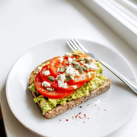 Toasted whole grain bread topped with velvety avocado, lemon juice, salt, and pepper, ready to serve for an easy snack.