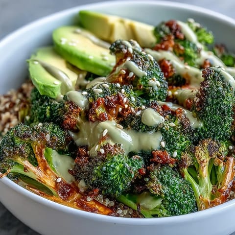 Perfectly golden, crispy roasted broccoli florets tossed with smoked paprika and red onion slices. This Mediterranean-inspired bowl is served over wholesome grains and garnished with fresh parsley and toasted sesame seeds.