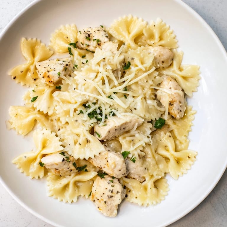 Creamy bowtie pasta with mozzarella, chicken, and rich garlic butter, ready to be enjoyed.