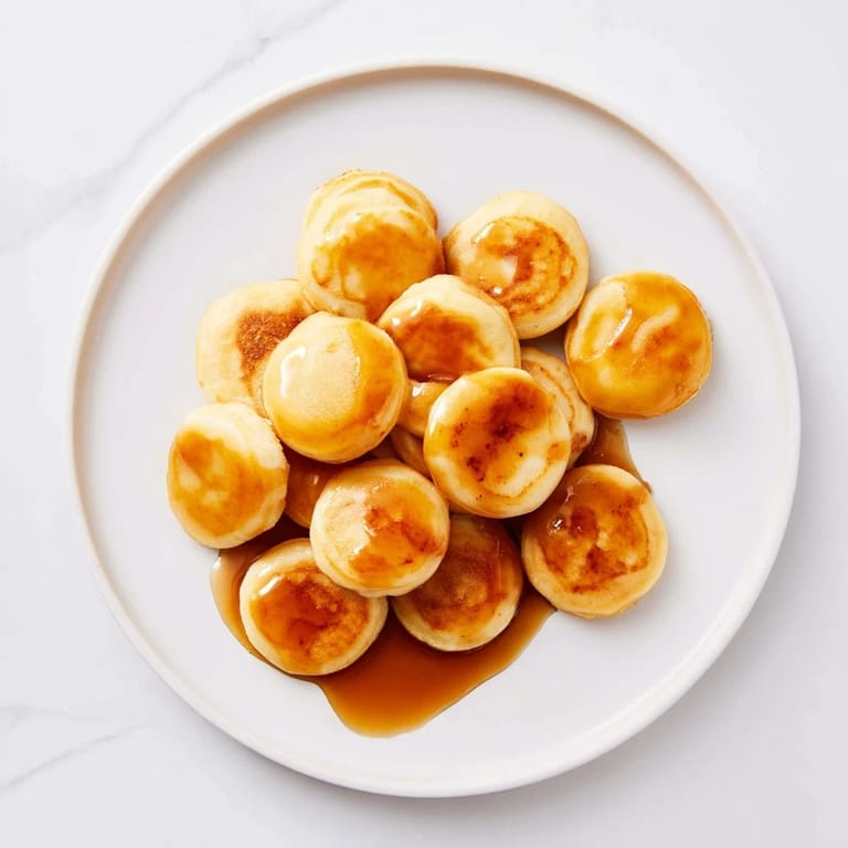 A delightful bowl of pancake cereal: tiny golden pancakes, ideal for brunch with fresh berries.