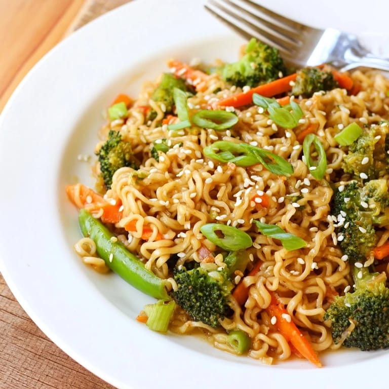A close-up of a flavorful ramen noodle stir-fry remix, ready to serve with fresh green onions.