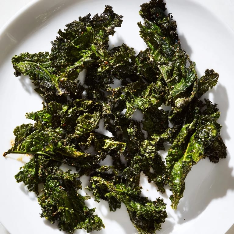 Oven-baked kale chips, perfectly crunchy and seasoned, ready to enjoy as a flavorful snack.
