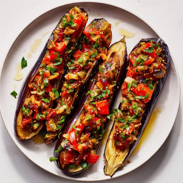 Fragrant tomato, onion, and garlic filling overflowing from tender eggplant halves of Imam Bayildi, a delicious Turkish meal.