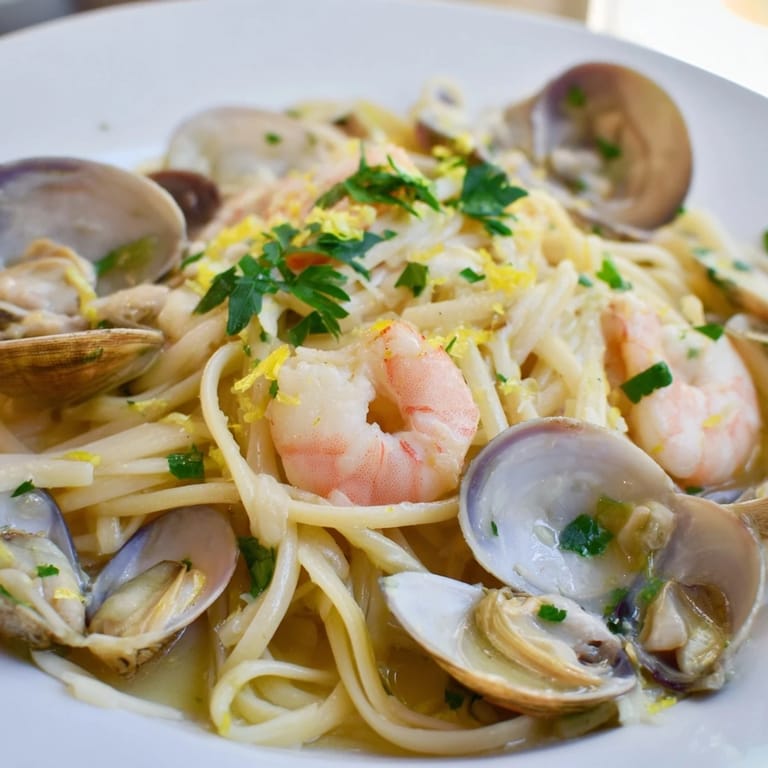 Plated Seafood Linguine with bright parsley, lemon wedges, and buttery white wine sauce, ready for a cozy Italian-inspired dinner.