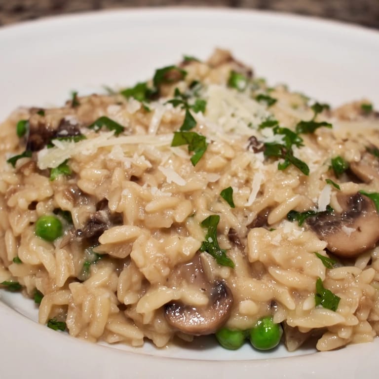 A comforting bowl of Orzo Mushroom Risotto-Style with sautéed mushrooms, peas, and a velvety sauce.