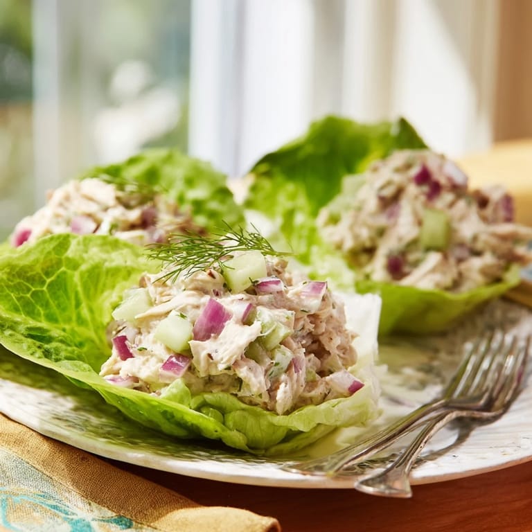 Savory Dill Pickle Chicken Salad nestled in crisp lettuce cups, dotted with red onion and celery.