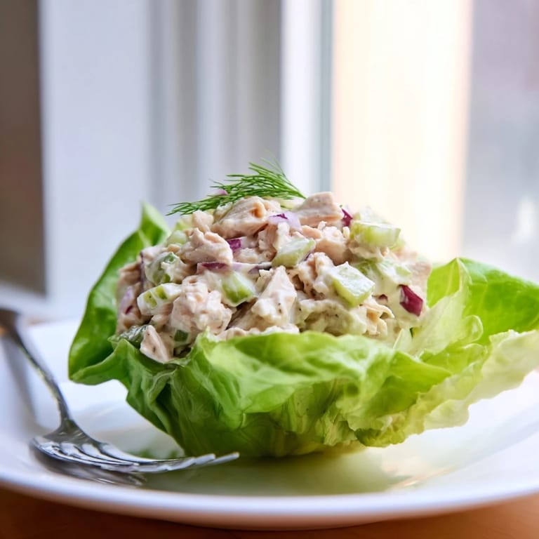 Freshly made Dill Pickle Chicken Salad served in vibrant green lettuce leaves for a low-carb meal.